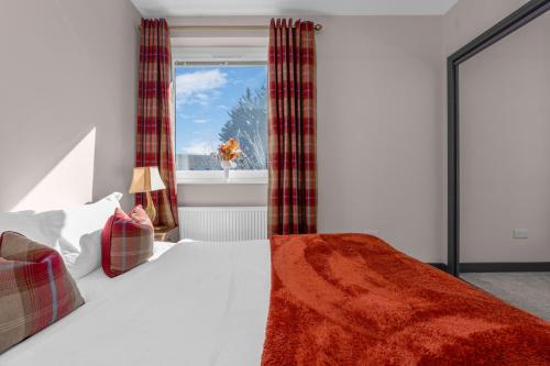 a bedroom with a bed and a window at Luxe 5 Bedroom Guardbridge House - St Andrews in St. Andrews