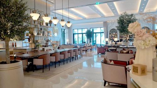 a restaurant with tables and chairs in a room at Palace Residences luxurious 2 bedroom with breathtaking views in Dubai