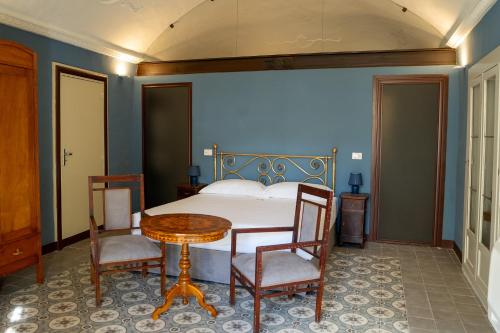 una camera da letto con un letto, un tavolo e delle sedie di Foresteria del Teatro Donnafugata a Ragusa