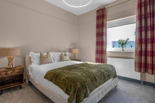 a bedroom with a large bed and a window at Luxe 5 Bedroom Guardbridge House - St Andrews in St. Andrews