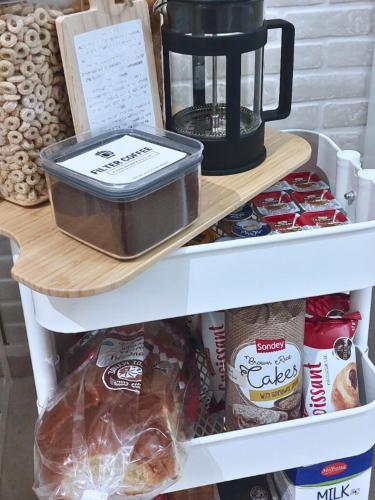 a shelf in a refrigerator with a coffee maker and food at Petras Luxury Suites in Athens