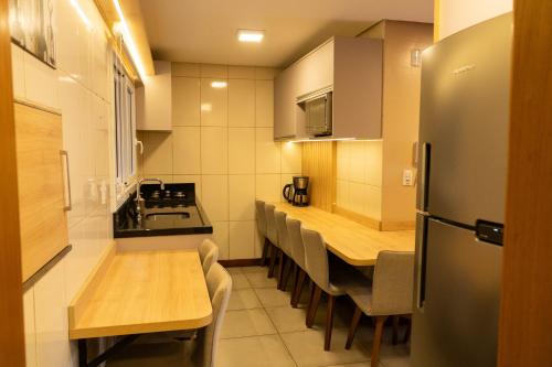 a small kitchen with a table and a refrigerator at Casa João e Maria - CANELA in Canela