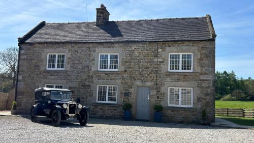 an old car parked in front of a brick house at Stunning 4 Bed Near Alton Towers, Polar Bears, Peak District in Waterfall