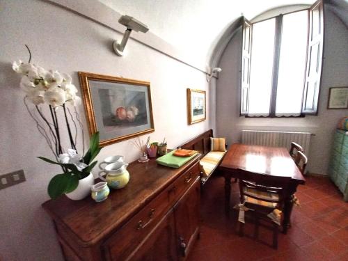 a room with a wooden dresser and a table with flowers on it at Dal Teatro - Imola Centro in Imola