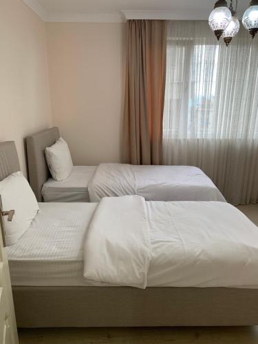 Esa Apart Hotel في طرابزون: غرفة نوم بها سريرين ونافذة