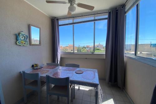 ein Esszimmer mit Tisch und Stühlen und einem großen Fenster in der Unterkunft Sea & Relaxation Stay in Frontignan