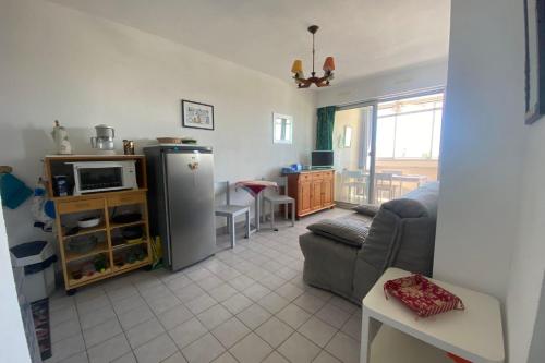 ein Wohnzimmer mit Couch und Kühlschrank in der Unterkunft Sea & Relaxation Stay in Frontignan