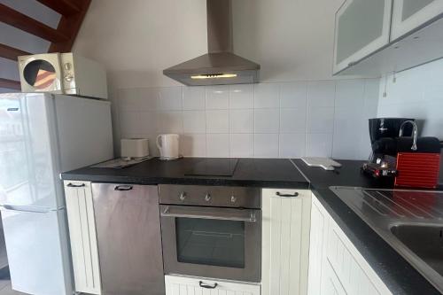 une cuisine avec une cuisinière et un réfrigérateur dans l'établissement Between Sky and Waves, à Aresquies