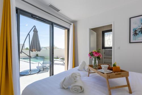 - une chambre avec un lit et une vue sur une terrasse dans l'établissement Villa Miray - Beach & Pool, à Sérignan