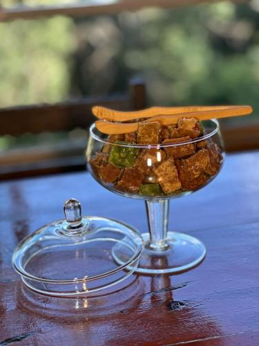 a glass bowl of food sitting on a table at Pousada Flor da Mata in Nova Lima