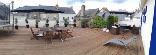 a balcony with a table and chairs and umbrellas at Maison familiale charmante à Ingrandes in Ingrandes