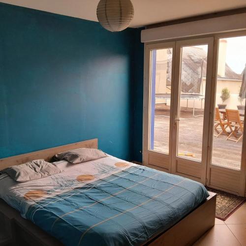 une chambre avec un lit et une porte coulissante en verre dans l'établissement Maison familiale charmante à Ingrandes, à Ingrandes