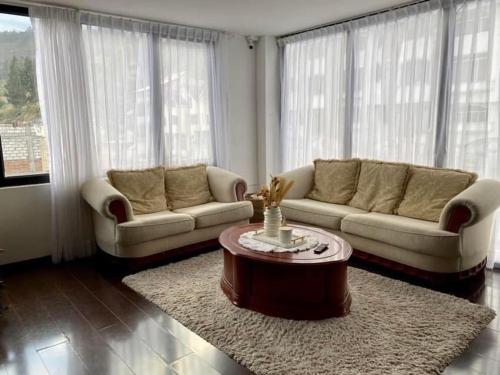 a living room with two couches and a coffee table at Departamento de Lujo en Ambato in Huamboya