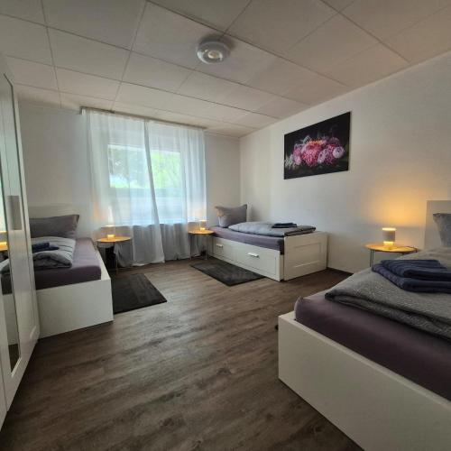 a bedroom with two beds and a window at Budget Base Apartment - 3 x Einzelzimmer in Braunschweig
