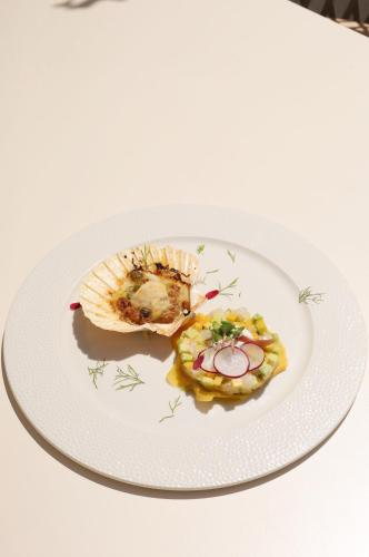 a white plate with food on a table at Hotel Medistone in Omiš