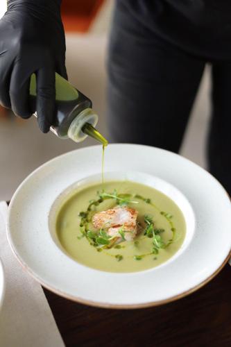 a person is pouring sauce into a bowl of soup at Hotel Medistone in Omiš