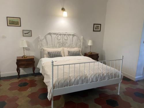 a bedroom with a white bed and two night stands at Cà Bianca in Casorzo