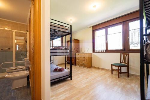 una habitación con dos literas y una silla en Casina de Arroes By Silastur, en Arroes