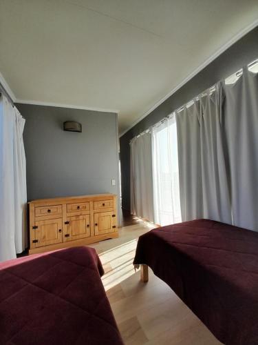 a bedroom with two beds and a dresser and a window at Aroma de la sierra in Villa Serrana