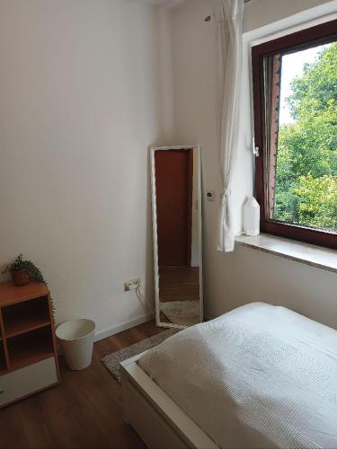 a bedroom with a mirror and a bed and a window at Ruhige Ortsrandlage 2 in Kiel