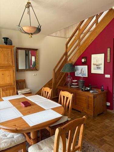 une salle à manger avec une table en bois et un escalier dans l'établissement La maison des castors, à Paimpol