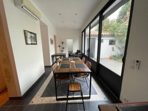 une salle à manger avec une table et une grande fenêtre dans l'établissement MAISON - Authentique échoppe Bordelaise avec jardin, à Bordeaux