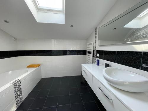 une salle de bain avec un lavabo, une baignoire et un miroir dans l'établissement MAISON - Authentique échoppe Bordelaise avec jardin, à Bordeaux