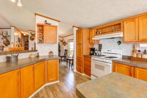 a kitchen with wooden cabinets and a white stove top oven at Tallman Lake Access Family-Friendly Home with Dock! in Fountain