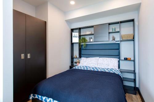 a bedroom with a blue bed with a blue headboard at Yugo Explore New Mill in Dublin