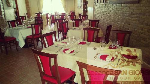 a dining room with white tables and red chairs at Locanda San Giorgio in Termoli