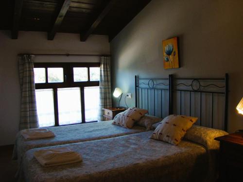 a bedroom with a large bed with a large window at APARTAMENTOS MARIAJE in Barro de Llanes