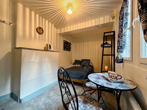 a small room with a bed and a table and chairs at La Chambre du Chateau - Center of Carentan in Carentan