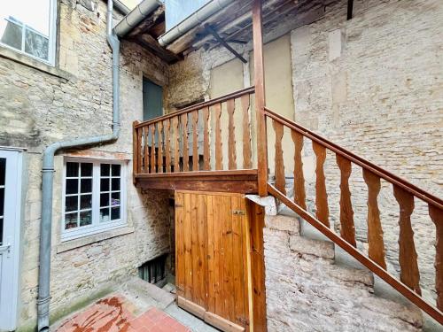 a wooden staircase leading to a building with a door at La Chambre du Chateau - Center of Carentan in Carentan