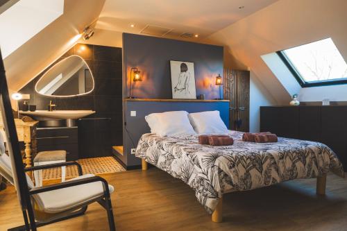- une chambre avec un lit, un lavabo et un miroir dans l'établissement La maison de marie, à Epiniac