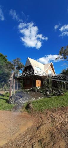 a house with a roof on top of a field at Pousada das Nascentes in Catas Altas