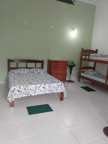 a bedroom with a bed and a dresser in it at Casa do Pescador in Peruíbe