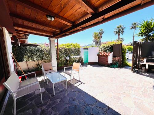 a patio with chairs and a table and a television at Appartamento San Teodoro III in San Teodoro