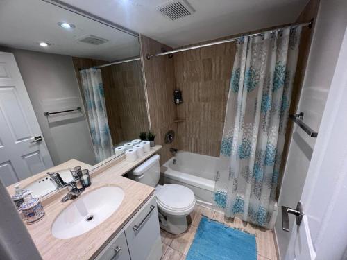 a bathroom with a sink and a toilet and a tub at Downtown Central Residences in Montréal