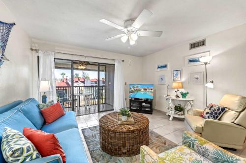 a living room with a blue couch and a ceiling fan at Dans Florida Condos Sea Life at Runaway Bay in Bradenton Beach