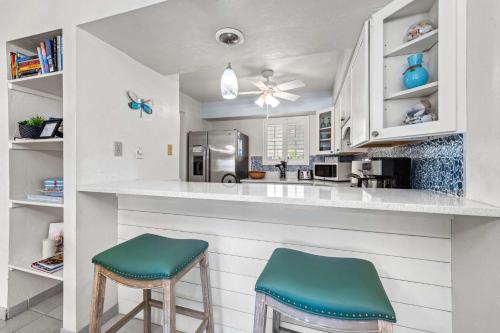 a kitchen with two stools sitting at a counter at Dans Florida Condos Sea Life at Runaway Bay in Bradenton Beach