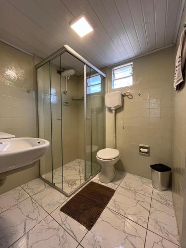 a bathroom with a shower and a toilet and a sink at Casa 89 in Diamantina