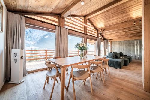 une salle à manger avec une table et des chaises en bois dans l'établissement Chalet Foxden, aux Houches