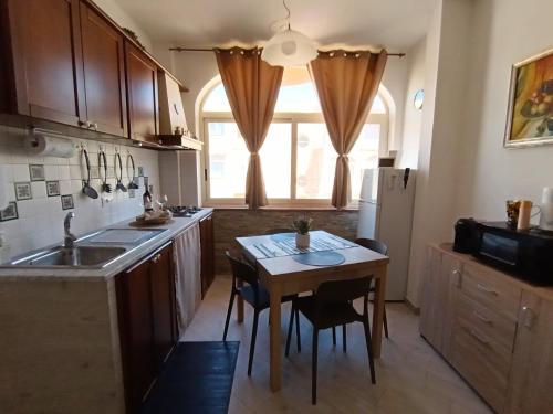 a kitchen with a table and a small table with chairs at Mondello Sea House in Palermo