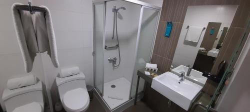 a bathroom with a toilet and a shower and a sink at Open Hotel in Quillota