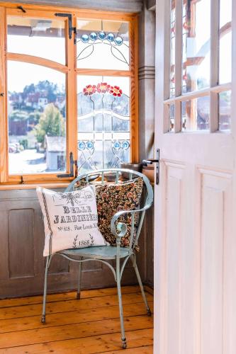 a chair with a pillow on it in front of a window at Landhaus Fröbel in Bad Liebenstein
