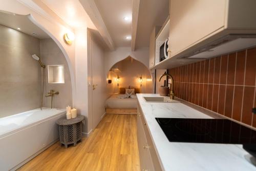 La salle de bains est pourvue de 2 lavabos, d'une baignoire et d'un lit. dans l'établissement Les Suites d Ailleurs, à Nice