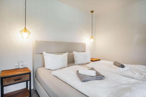 a bedroom with two beds with white sheets and pillows at Meer in Sicht in Eckernförde