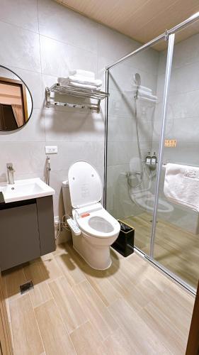 a bathroom with a shower and a toilet and a sink at 隱 Villa 旅宿 in Chaozhou