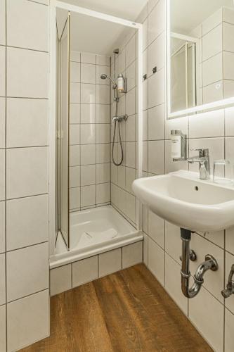 a white bathroom with a shower and a sink at Hotel Seepferdchen Zimmer 3 Eckernförde Self-Check-In in Eckernförde