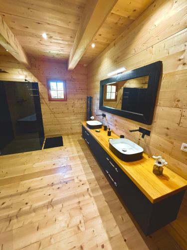 une salle de bain avec deux lavabos et un grand miroir dans l'établissement Maison en pierre, à Grignan